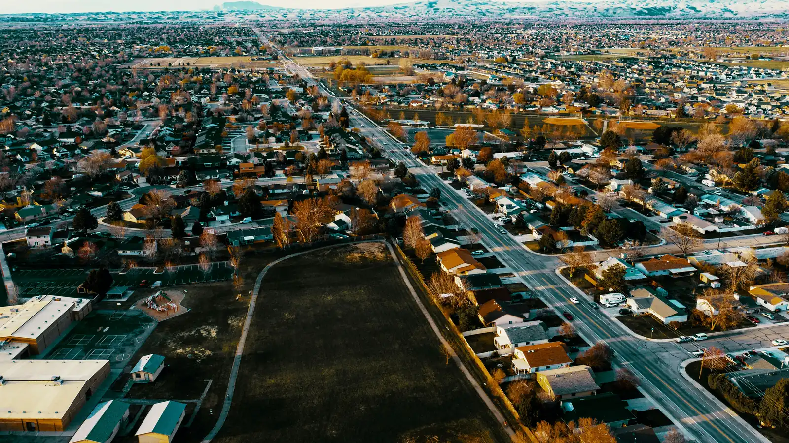 Aerial view of a residential neighborhood along a long straight road
