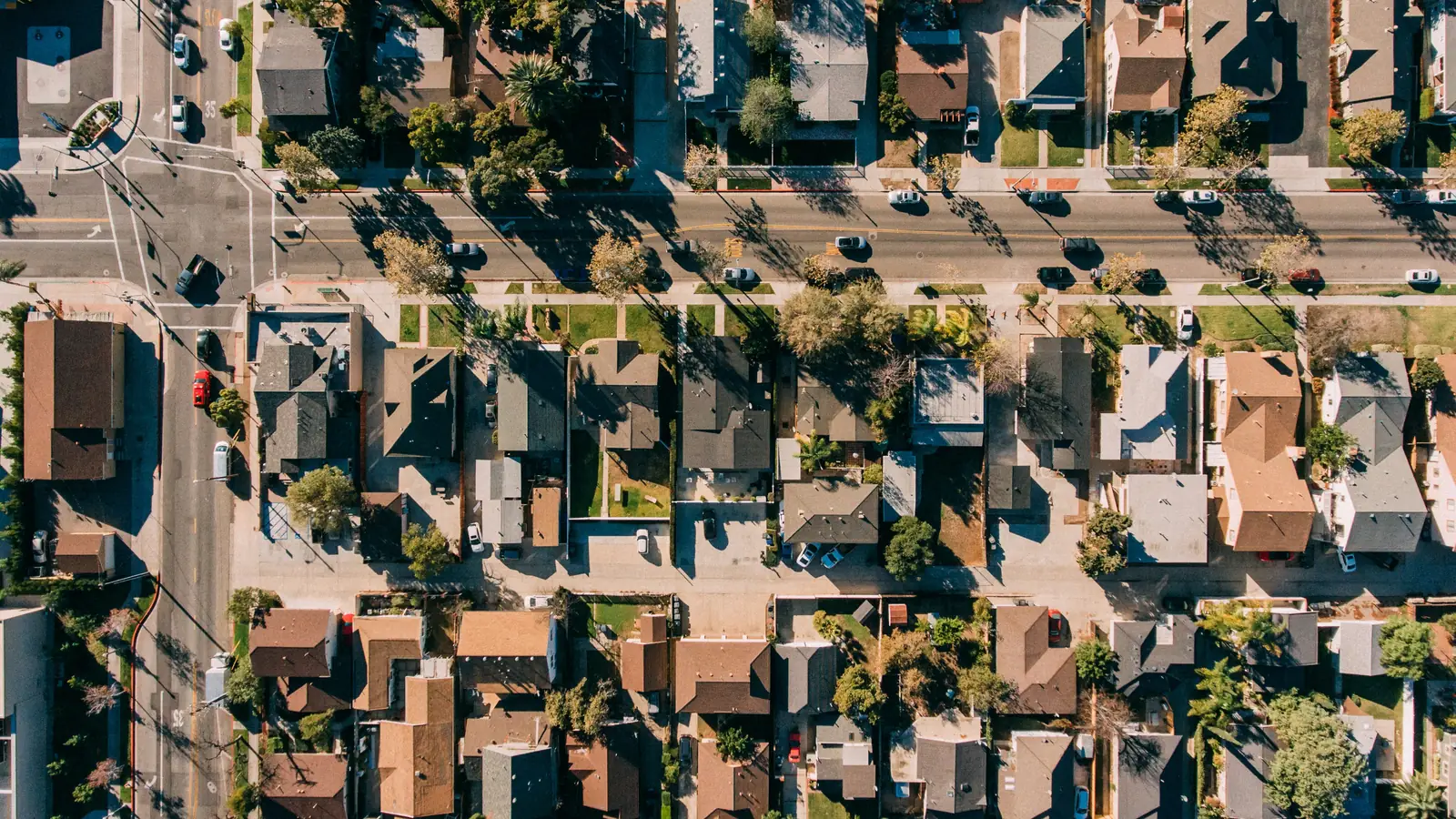 Top-down aerial view of rows of single-family houses, yards and streets