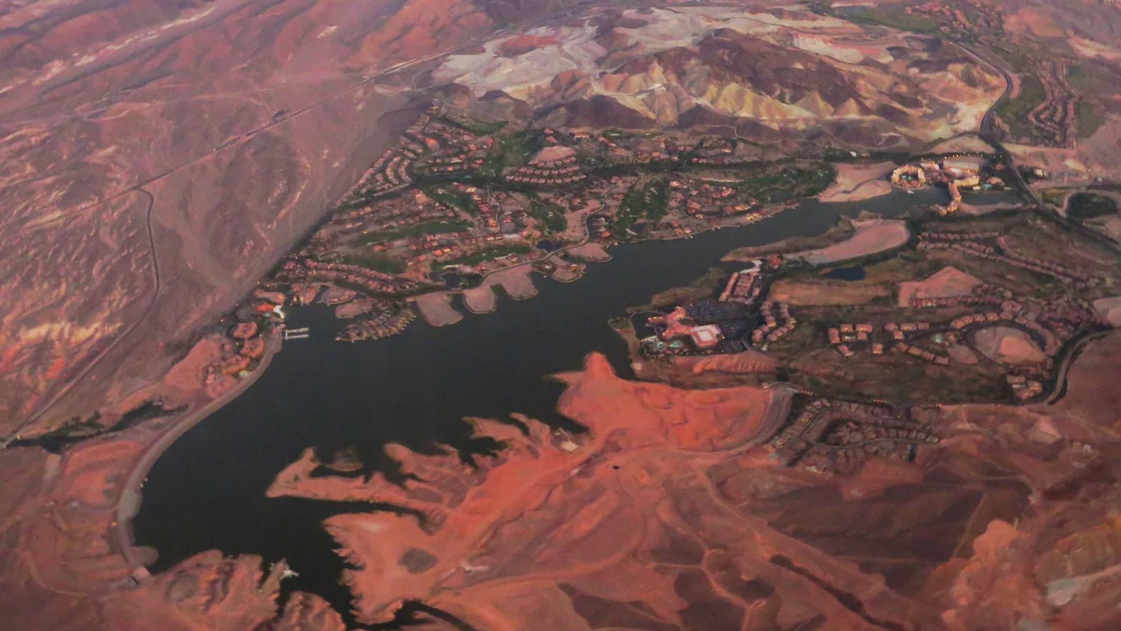 Aerial view of Lake Las Vegas in Henderson with homes and fairways around the lake and red desert hills