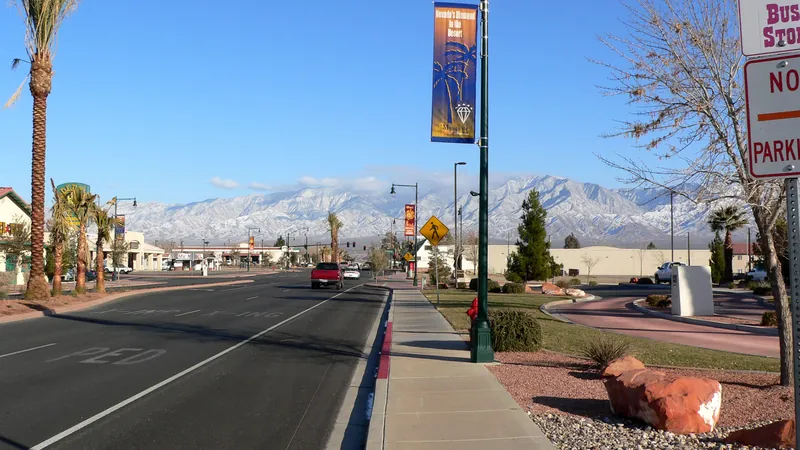 Street in Mesquite, Nevada, with palm trees and snow-capped mountains behind