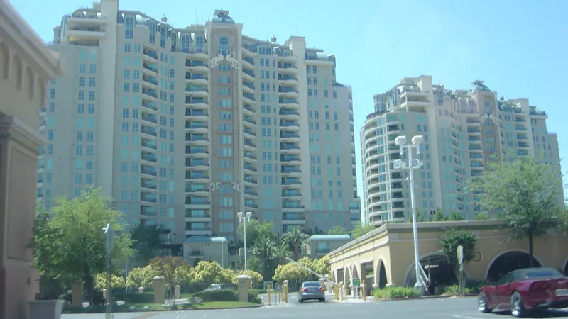 Two tall residential towers with a landscaped entrance in Las Vegas